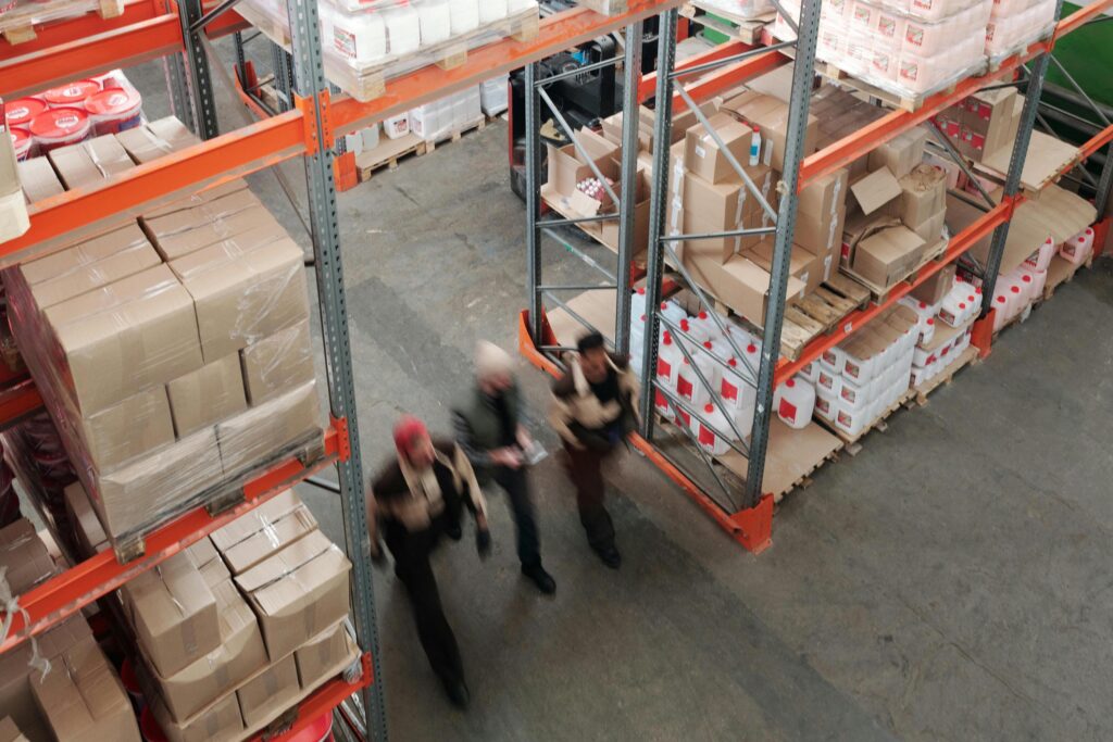 Group of three workers walk through an industrial warehouse