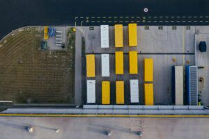 Aerial view of shipping contains sitting on a warehouse parking lot.